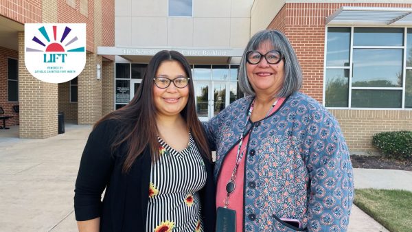2 women stand side by side in front of office building