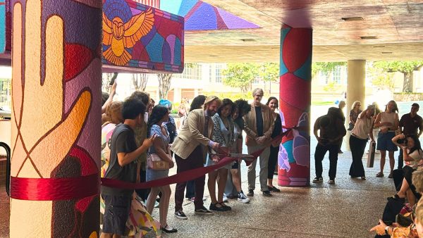 Group of students and staff cut ribbon for mural