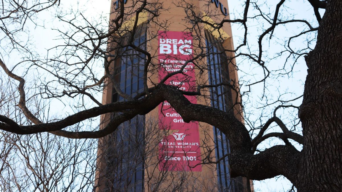 View of TWU ACT tower banner through dark tree branches