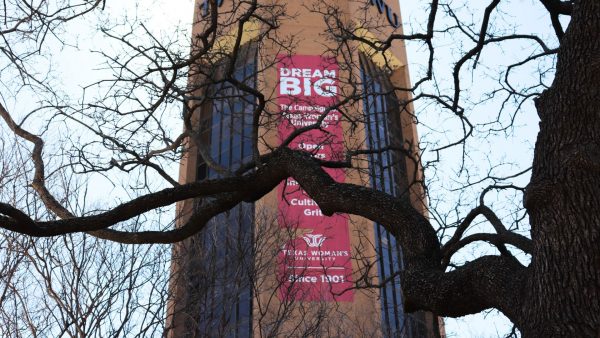 View of TWU ACT tower banner through dark tree branches