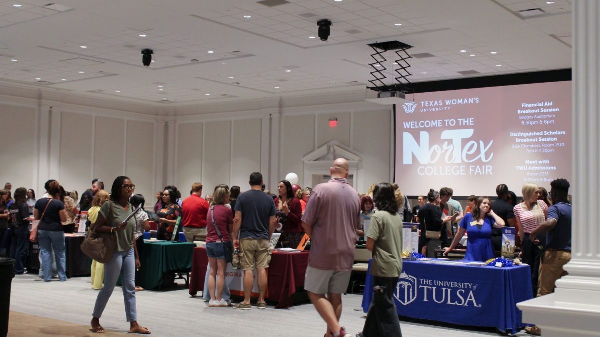 Students and parents at college fair tabling inside