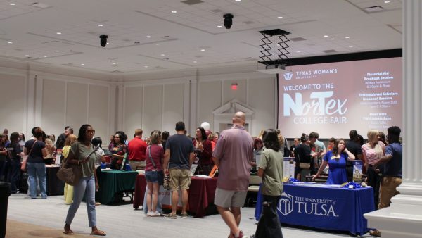 Students and parents at college fair tabling inside